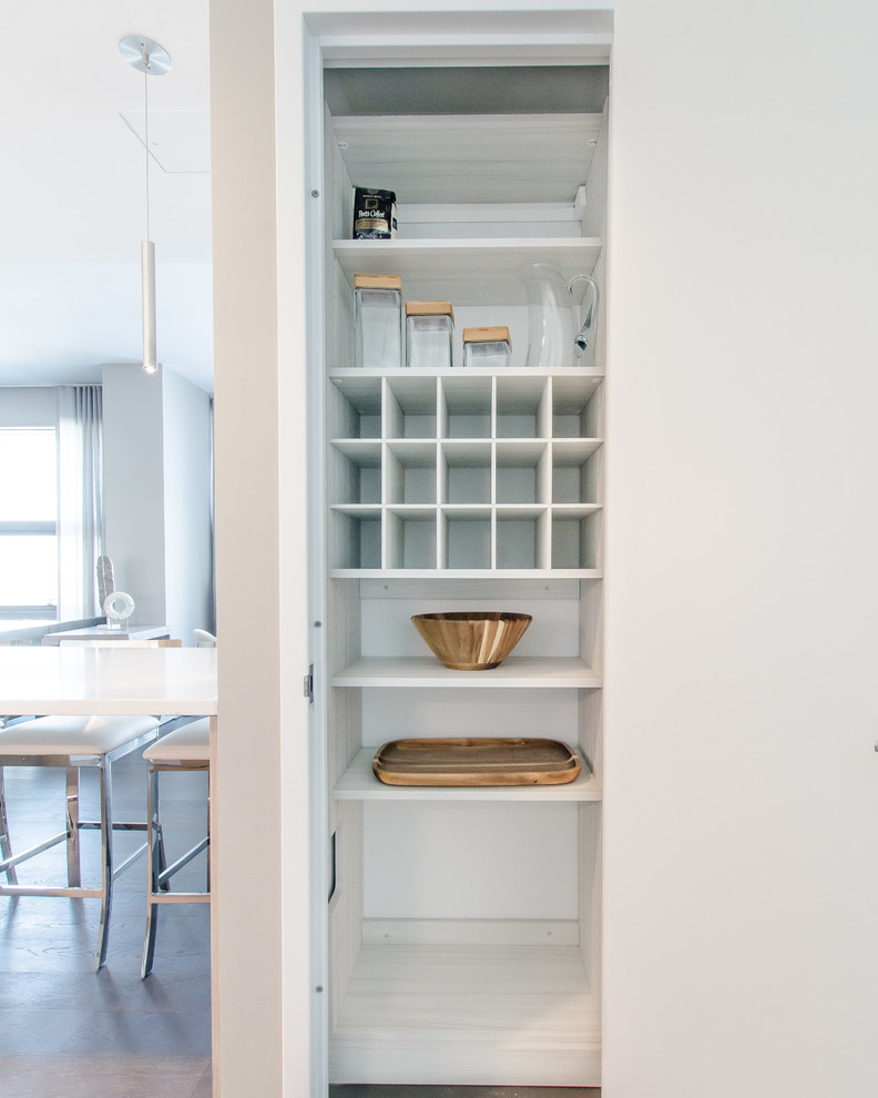 Photo of a small modern gender neutral wardrobe in New York with light wood cabinets.