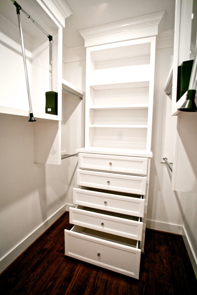 Modelo de armario vestidor unisex tradicional renovado de tamaño medio con armarios con paneles empotrados, puertas de armario blancas y suelo de madera en tonos medios