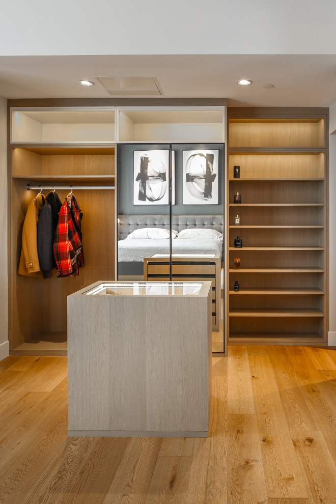 This is an example of an expansive contemporary gender neutral walk-in wardrobe in Vancouver with open cabinets, light wood cabinets, light hardwood flooring and beige floors.