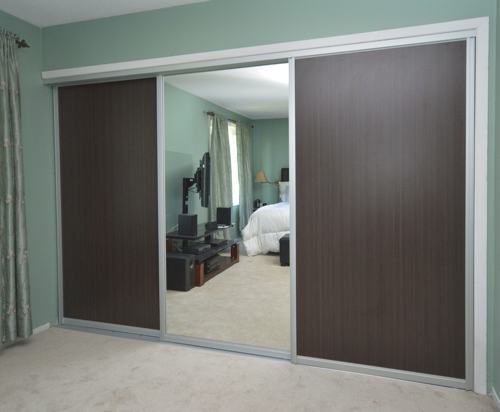 Imagen de armario y vestidor unisex contemporáneo de tamaño medio con puertas de armario de madera en tonos medios y moqueta