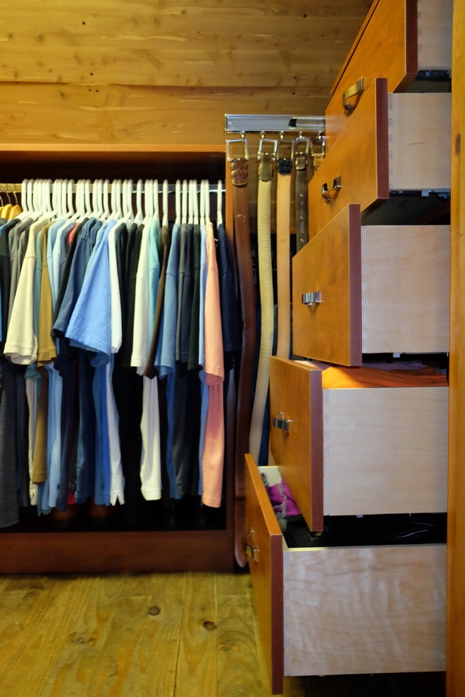 Ejemplo de armario vestidor de hombre contemporáneo pequeño con armarios con paneles lisos, puertas de armario de madera oscura y suelo de madera clara