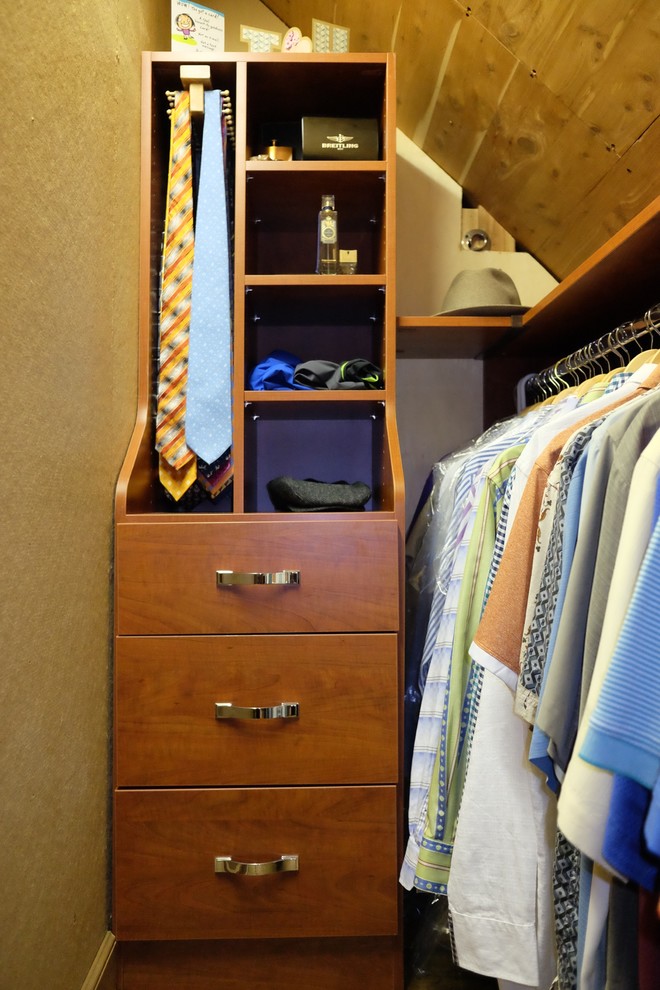 Diseño de armario vestidor de hombre contemporáneo pequeño con armarios con paneles lisos, puertas de armario de madera oscura y suelo de madera clara