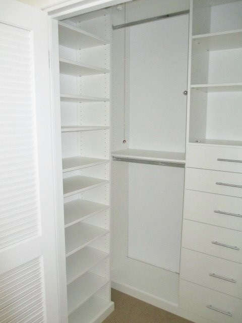 Small minimalist gender-neutral walk-in closet photo in Los Angeles with flat-panel cabinets and white cabinets