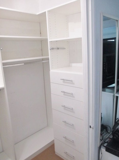 Immagine di una piccola cabina armadio unisex minimalista con ante lisce e ante bianche