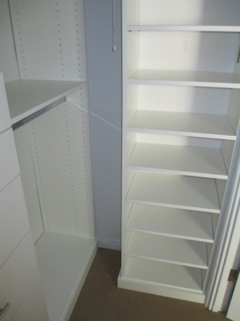 Diseño de armario vestidor unisex minimalista pequeño con armarios con paneles lisos y puertas de armario blancas
