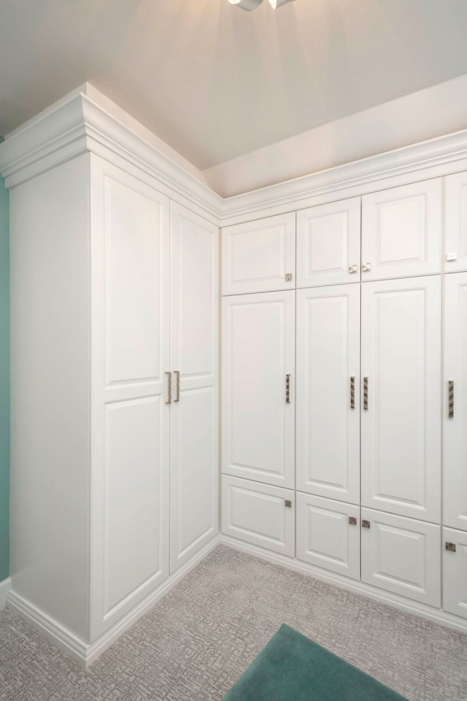 Cette image montre un petit dressing room traditionnel neutre avec des portes de placard blanches, moquette et un sol gris.