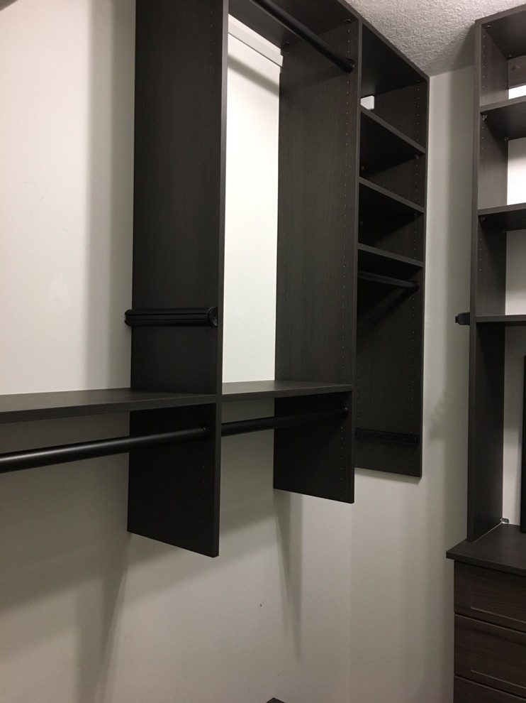 Ejemplo de armario vestidor unisex actual pequeño con armarios con paneles con relieve, puertas de armario de madera en tonos medios, moqueta y suelo beige