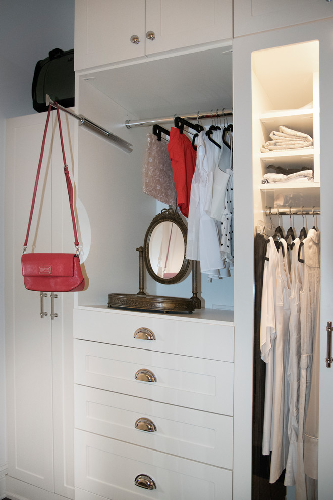 Ejemplo de armario vestidor de mujer clásico renovado de tamaño medio con armarios tipo vitrina, puertas de armario blancas, suelo de madera oscura y suelo marrón