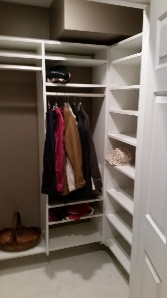 Imagen de armario vestidor unisex tradicional de tamaño medio con armarios abiertos, puertas de armario blancas y suelo de mármol