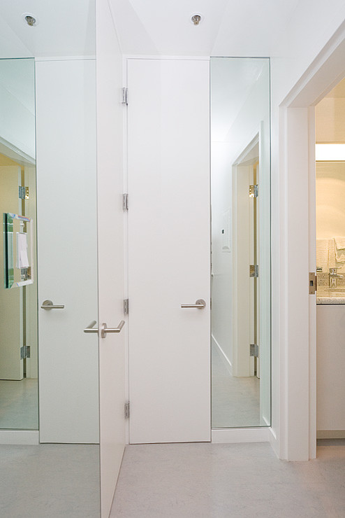 Foto de armario vestidor unisex minimalista grande con armarios con paneles lisos, puertas de armario blancas y suelo vinílico