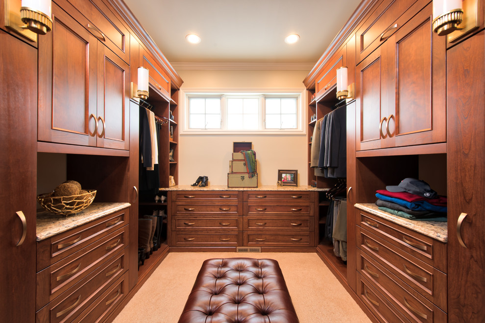 Modelo de armario vestidor unisex clásico de tamaño medio con armarios con paneles lisos, puertas de armario de madera oscura y moqueta