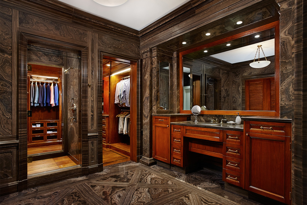 Foto på ett medelhavsstil omklädningsrum för män, med luckor med infälld panel, skåp i mörkt trä, marmorgolv och brunt golv