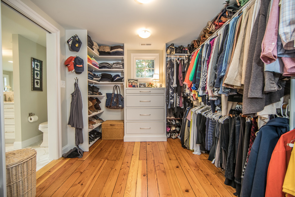 Photo of a large rustic gender neutral walk-in wardrobe in DC Metro with open cabinets, white cabinets, medium hardwood flooring and brown floors.