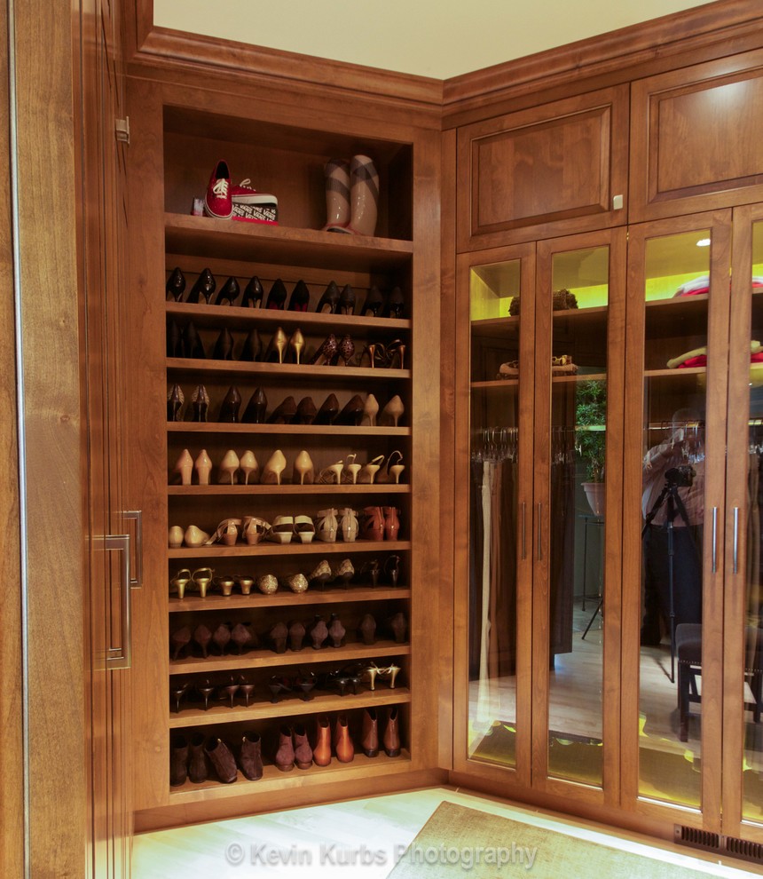 Ejemplo de armario vestidor unisex ecléctico extra grande con armarios con paneles con relieve, puertas de armario de madera oscura y suelo de madera clara