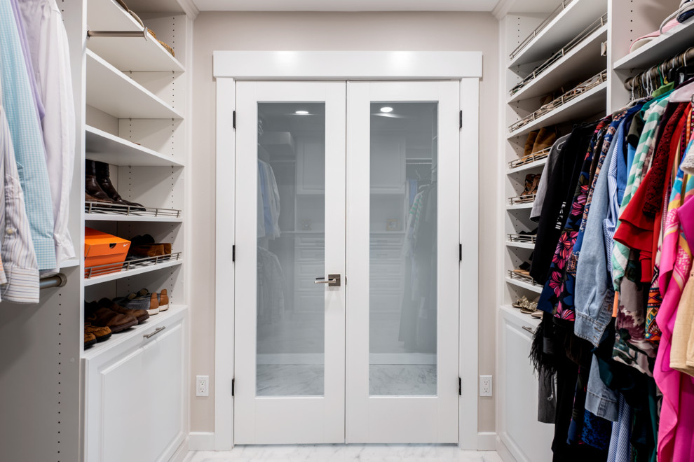 Ejemplo de vestidor unisex moderno grande con armarios con paneles con relieve, puertas de armario blancas, suelo de baldosas de porcelana y suelo blanco