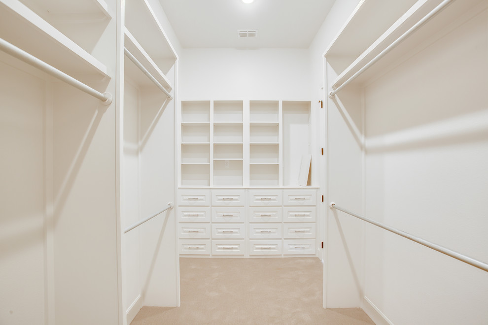 Exemple d'un grand dressing room chic neutre avec un placard avec porte à panneau surélevé, des portes de placard blanches, moquette et un sol beige.