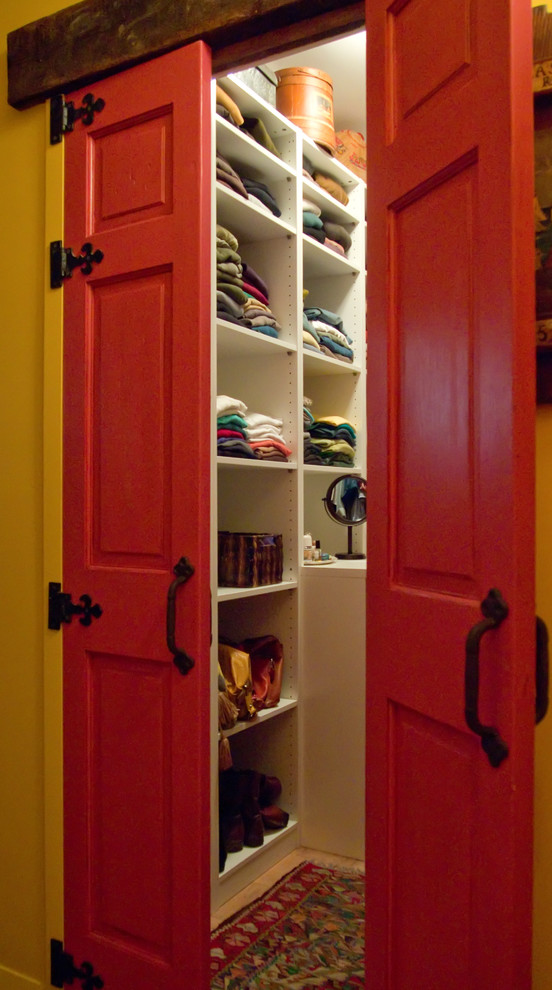 Diseño de armario vestidor unisex de estilo americano de tamaño medio con armarios abiertos, puertas de armario blancas, suelo de madera en tonos medios y suelo marrón