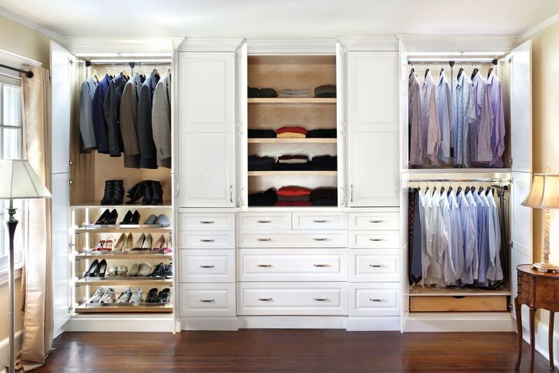 Imagen de armario vestidor unisex clásico renovado de tamaño medio con armarios con paneles con relieve, puertas de armario blancas y suelo de madera oscura