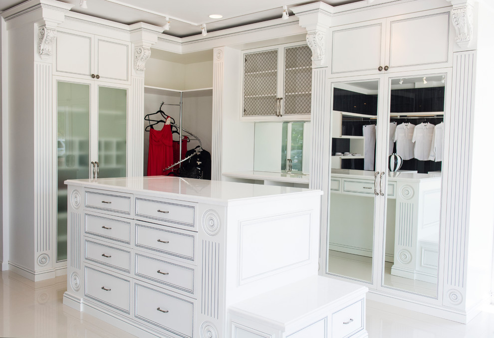 This is an example of a small traditional walk-in wardrobe for women in Los Angeles with recessed-panel cabinets, dark hardwood flooring and white cabinets.