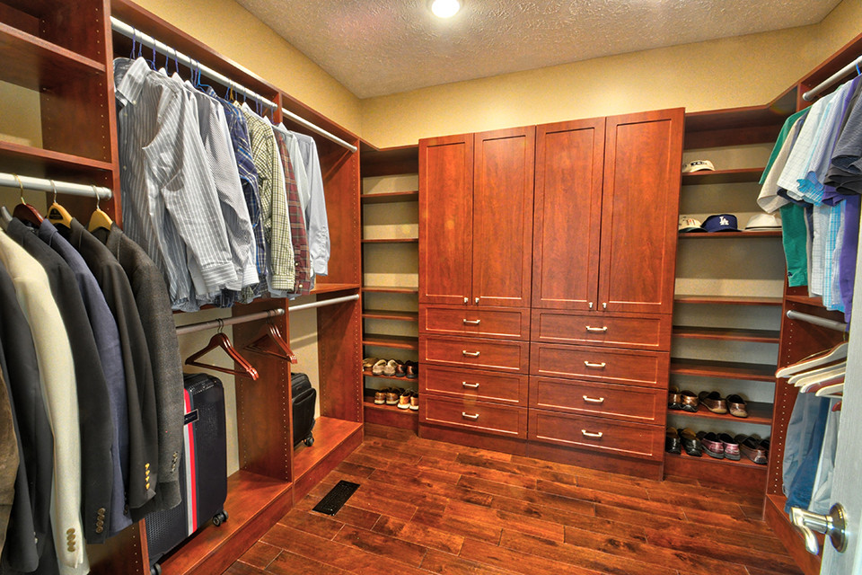 Ejemplo de armario vestidor unisex tradicional renovado grande con armarios estilo shaker, puertas de armario de madera oscura, suelo de madera en tonos medios y suelo marrón