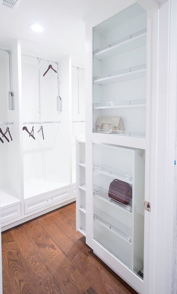 Diseño de armario vestidor unisex moderno pequeño con puertas de armario blancas, suelo de madera clara, suelo marrón y armarios estilo shaker