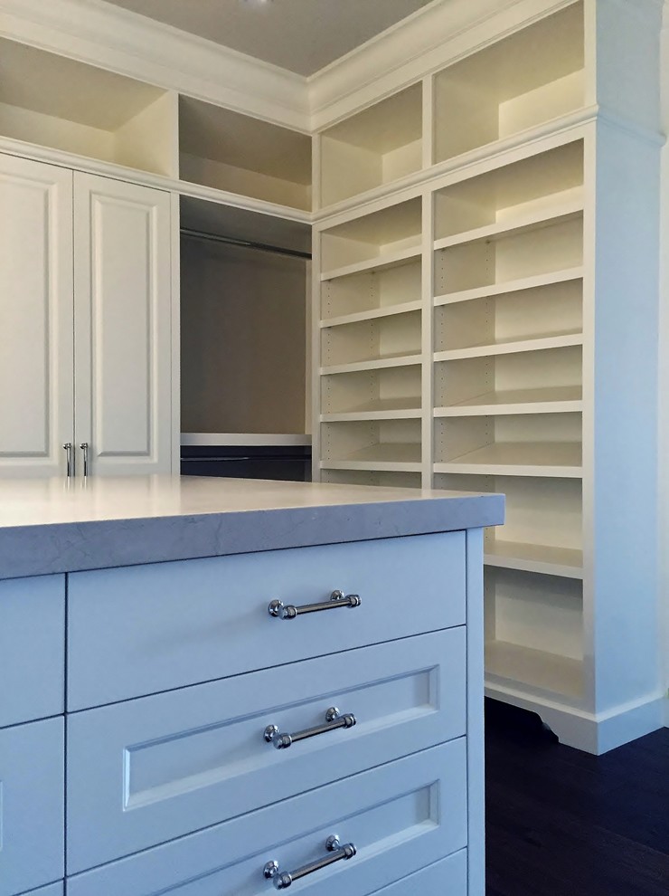 Example of a large tuscan gender-neutral dark wood floor dressing room design in Vancouver with raised-panel cabinets and white cabinets