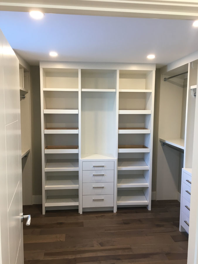 Walk-in closet - large modern gender-neutral medium tone wood floor and brown floor walk-in closet idea in Calgary with open cabinets and white cabinets