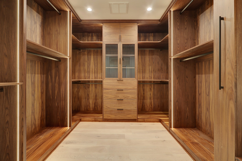 Esempio di una cabina armadio unisex design di medie dimensioni con ante lisce e ante in legno scuro