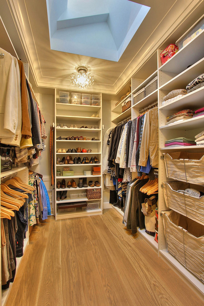 Example of a mid-sized transitional gender-neutral medium tone wood floor walk-in closet design in San Francisco with open cabinets and white cabinets