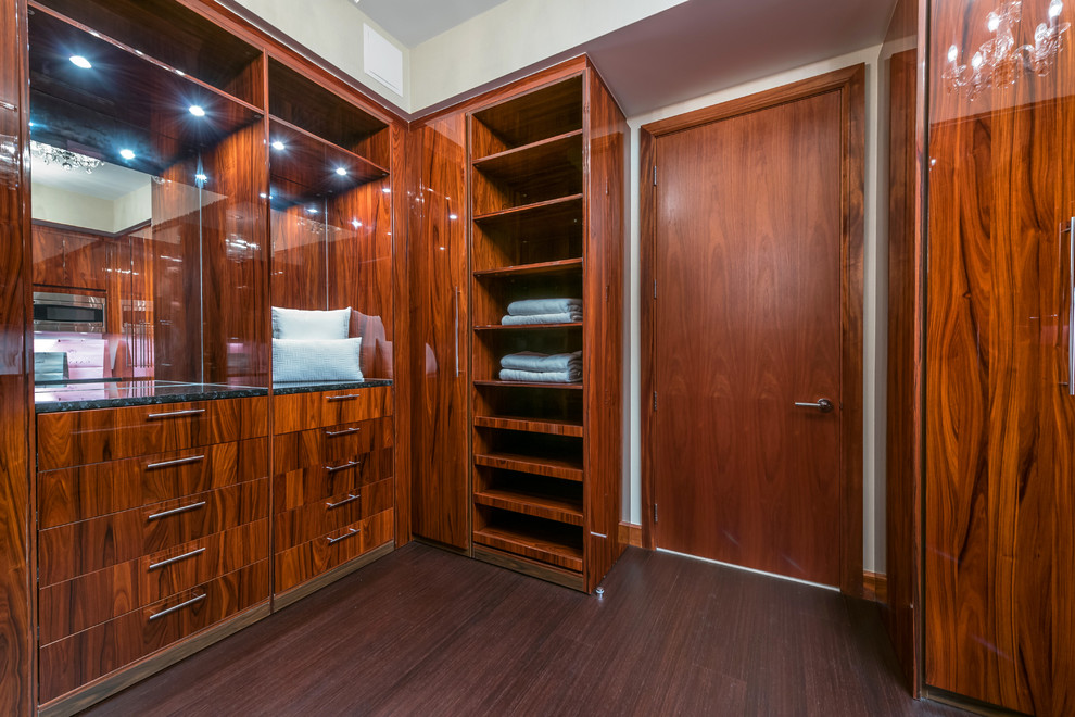 Modelo de armario y vestidor unisex tradicional renovado con armarios con paneles lisos, puertas de armario de madera en tonos medios y suelo de mármol