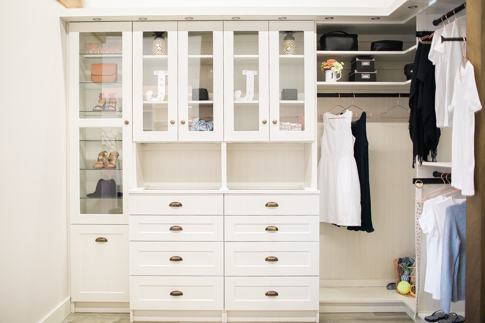 This is an example of a medium sized walk-in wardrobe for women in Other with shaker cabinets, light wood cabinets, light hardwood flooring and grey floors.