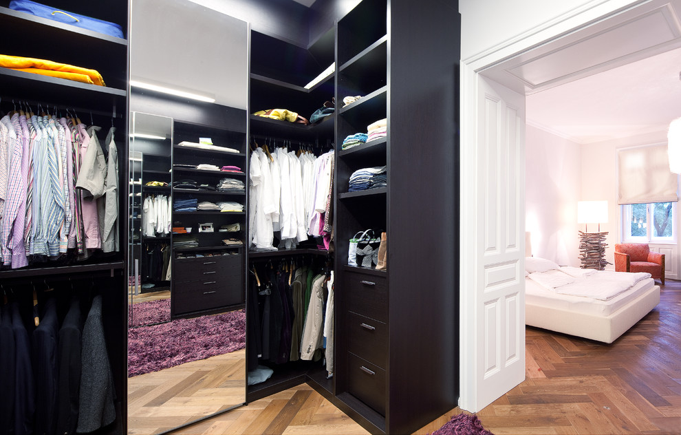 Diseño de armario vestidor unisex tradicional renovado grande con armarios con paneles lisos, puertas de armario de madera en tonos medios y suelo de madera en tonos medios