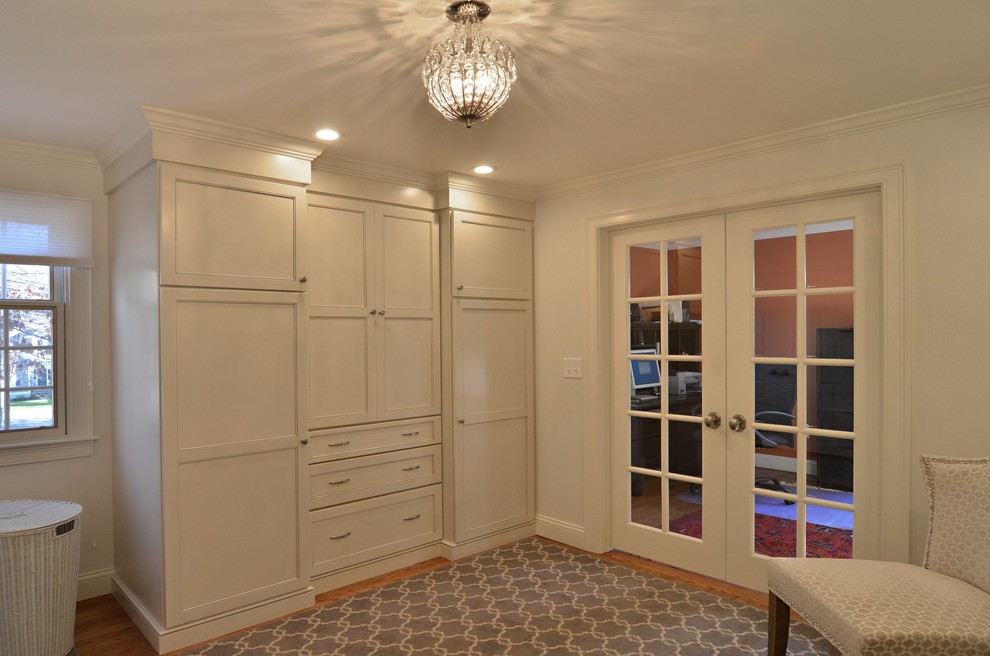 Aménagement d'un dressing room classique avec un placard à porte shaker, des portes de placard blanches et parquet clair.