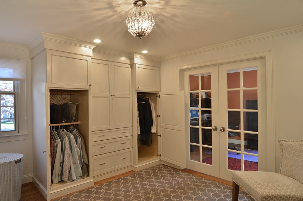 Imagen de vestidor tradicional renovado con armarios estilo shaker, puertas de armario blancas y suelo de madera clara