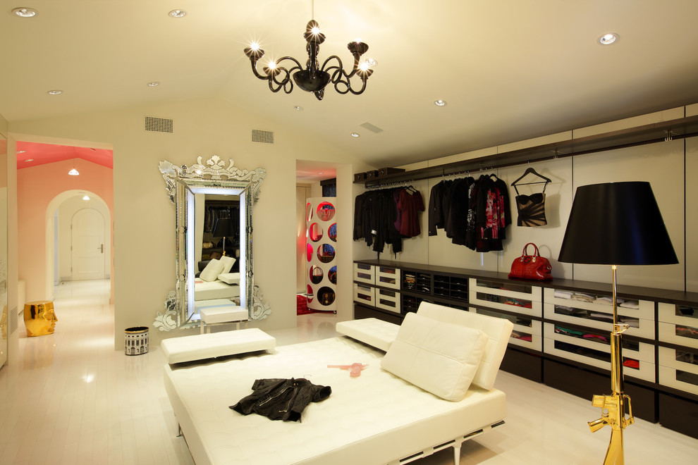 На фото: огромная гардеробная комната в средиземноморском стиле с стеклянными фасадами, белыми фасадами и полом из керамогранита для женщин