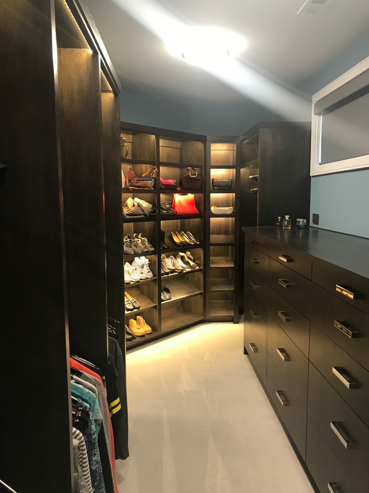 Diseño de armario vestidor unisex minimalista extra grande con armarios con paneles lisos, puertas de armario de madera en tonos medios, moqueta y suelo beige