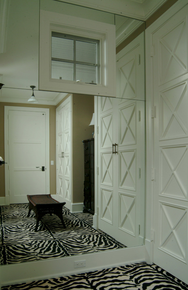 Geräumiges, Neutrales Ankleidezimmer mit Ankleidebereich, Schrankfronten mit vertiefter Füllung, weißen Schränken und Teppichboden in Miami