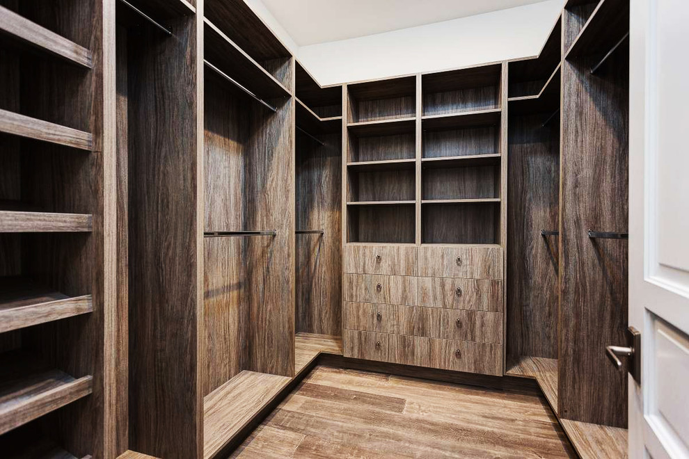 Diseño de armario vestidor unisex mediterráneo con suelo de madera oscura