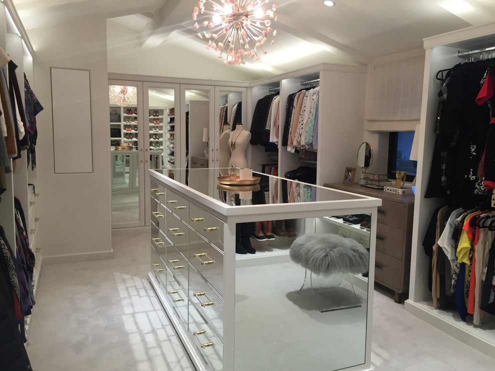 Design ideas for a large traditional dressing room for women in Los Angeles with glass-front cabinets, white cabinets, carpet and beige floors.