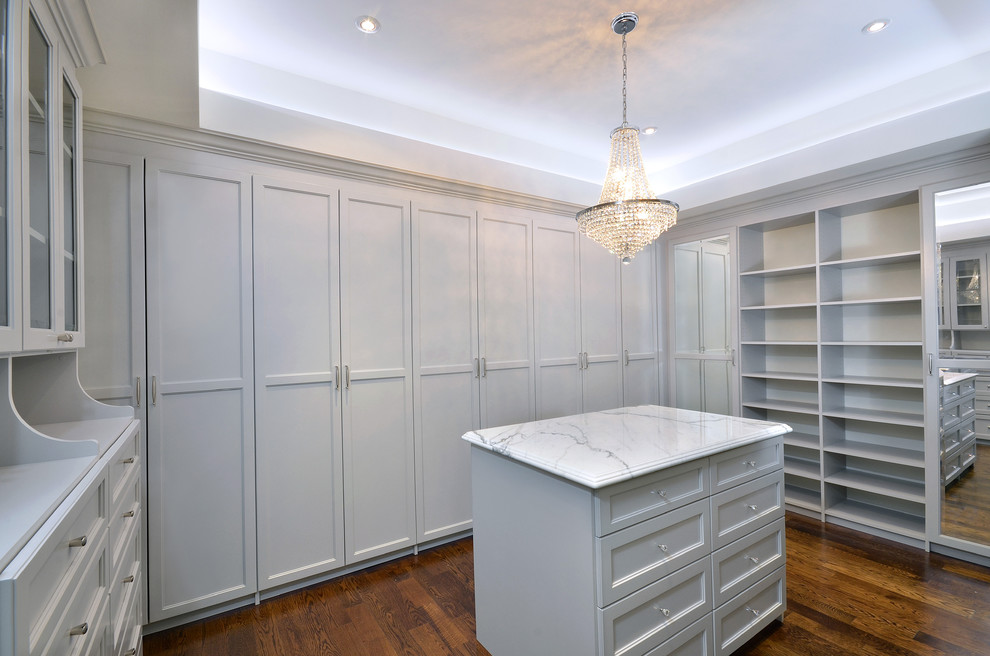 Example of a huge trendy gender-neutral dark wood floor dressing room design in Toronto with white cabinets
