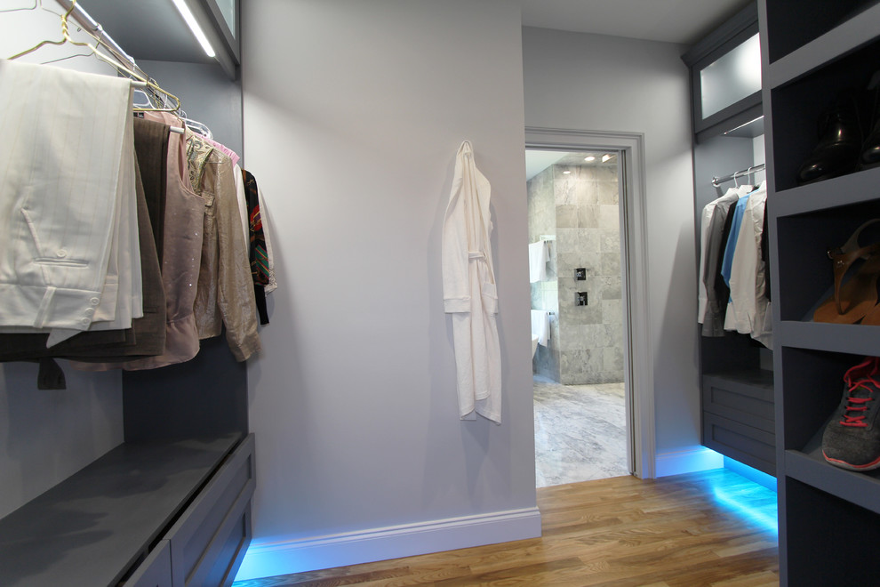 Ejemplo de vestidor unisex actual de tamaño medio con armarios estilo shaker, puertas de armario grises y suelo de madera clara