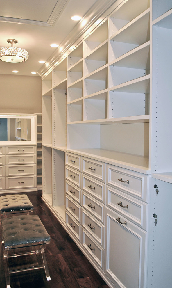 Large classic gender neutral dressing room in New York with shaker cabinets, white cabinets, dark hardwood flooring and brown floors.