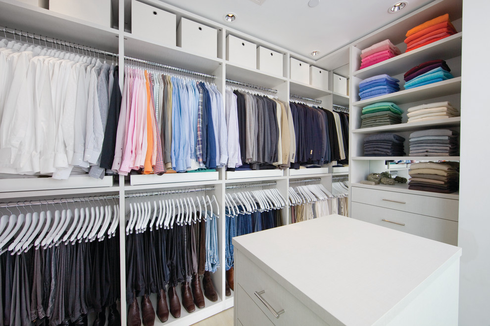 Imagen de armario vestidor unisex minimalista de tamaño medio con armarios con paneles lisos, puertas de armario blancas y suelo de madera clara