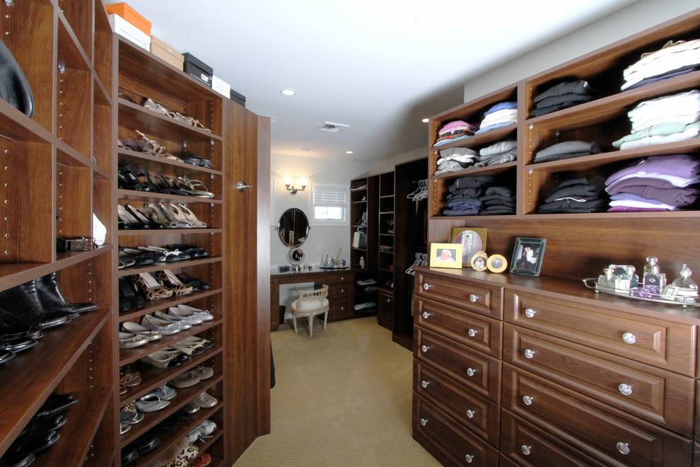 Large transitional gender-neutral carpeted and brown floor walk-in closet photo in New York with raised-panel cabinets and dark wood cabinets