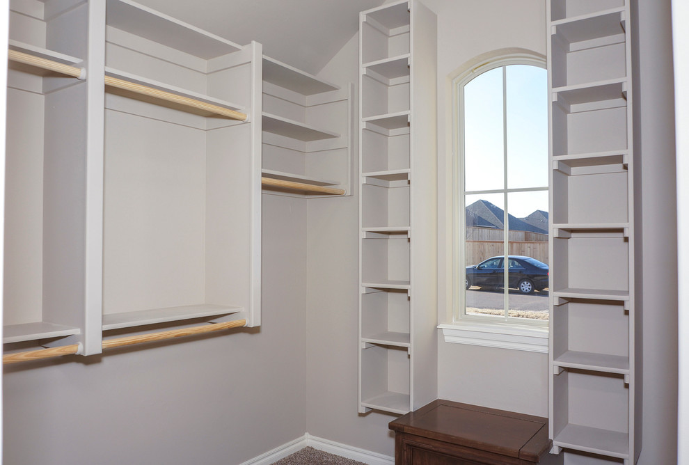 Пример оригинального дизайна: большая гардеробная комната унисекс в классическом стиле с открытыми фасадами, серыми фасадами и ковровым покрытием