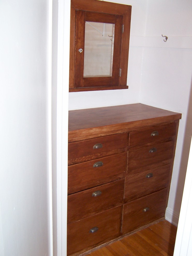 Ejemplo de armario vestidor unisex mediterráneo de tamaño medio con puertas de armario de madera oscura y suelo de madera en tonos medios