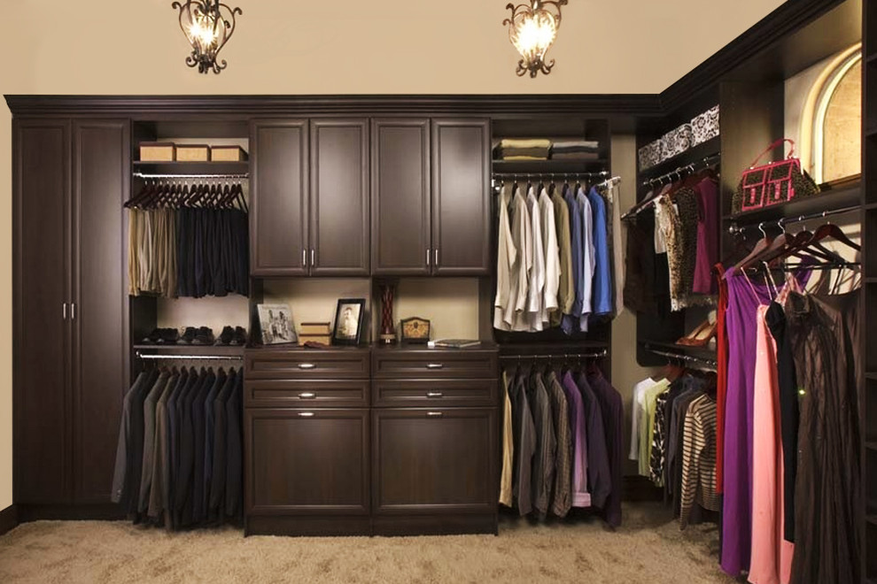 Inspiration for a large traditional gender neutral walk-in wardrobe in Philadelphia with raised-panel cabinets, dark wood cabinets, carpet and beige floors.