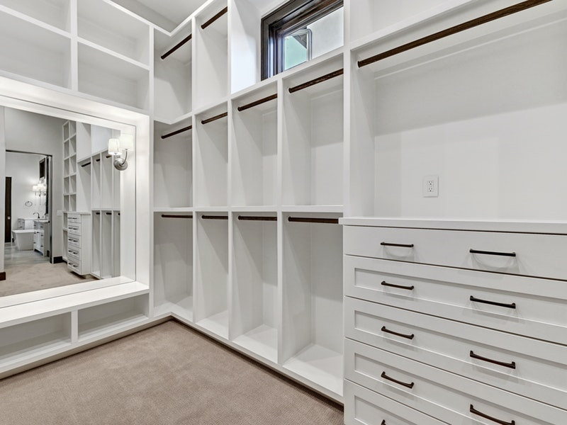 Diseño de armario vestidor unisex tradicional renovado grande con armarios estilo shaker, puertas de armario blancas, moqueta y suelo beige