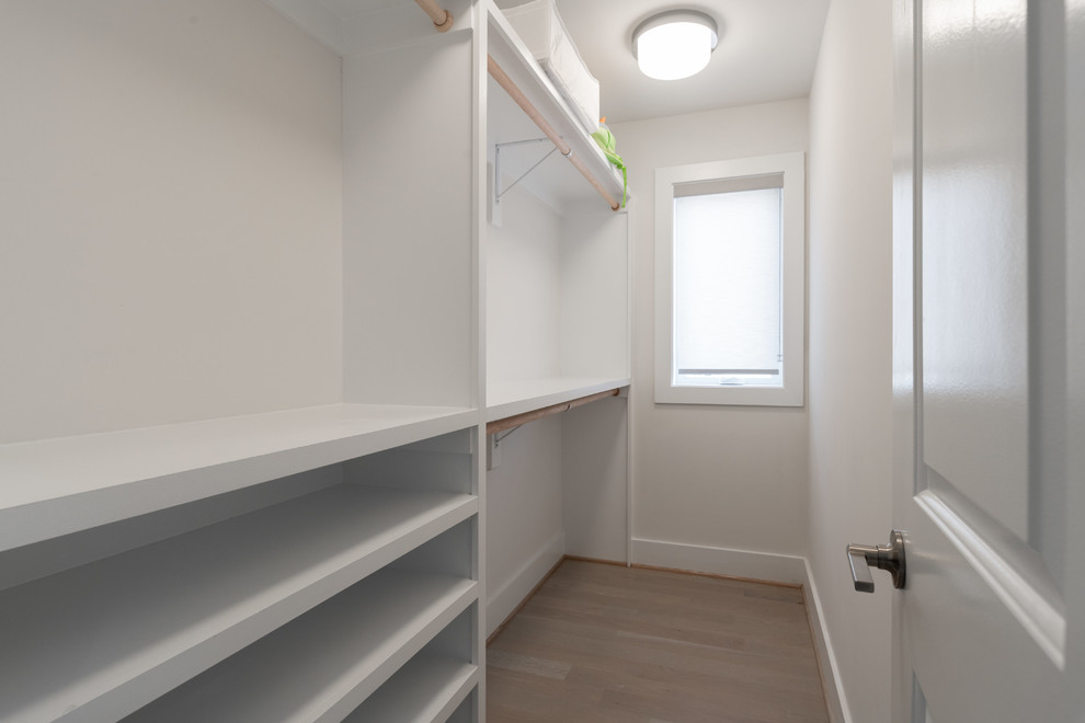 Idee per una cabina armadio unisex minimal di medie dimensioni con parquet chiaro e pavimento marrone