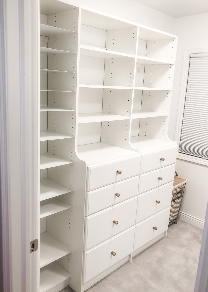 Modelo de armario vestidor unisex contemporáneo de tamaño medio con armarios con paneles lisos, puertas de armario blancas, moqueta y suelo gris